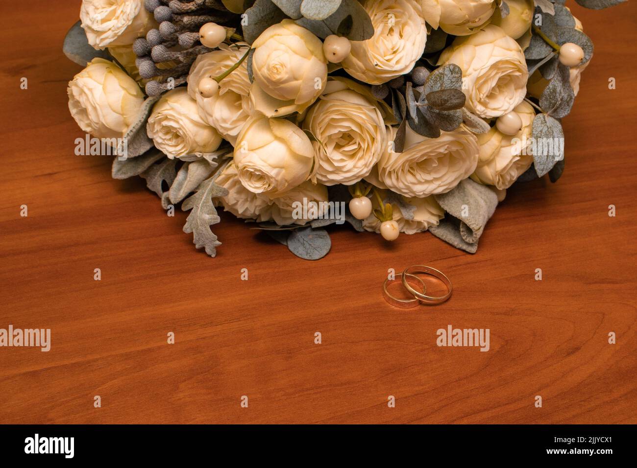 Un colpo di primo piano di un bouquet e anelli di nozze sul tavolo - concetto di matrimonio Foto Stock