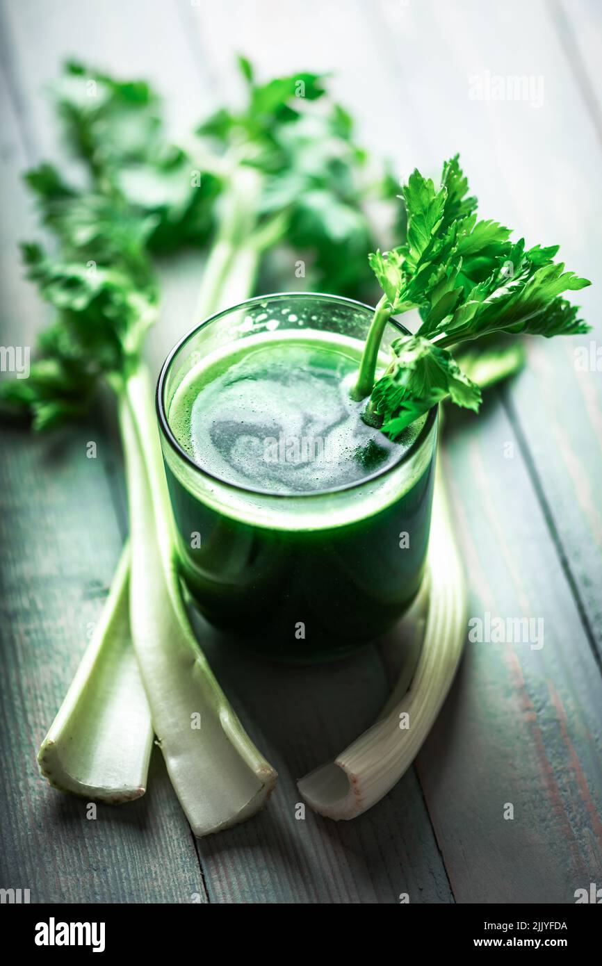 Sedano succo verde fresco in vetro su sfondo di legno. Concetto di cibo vegetariano sano Foto Stock