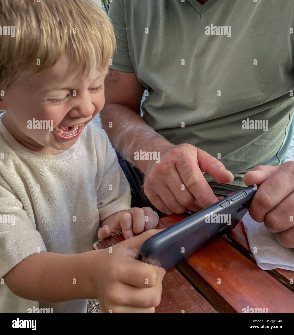 Un bambino è contento di uno smartphone Foto Stock