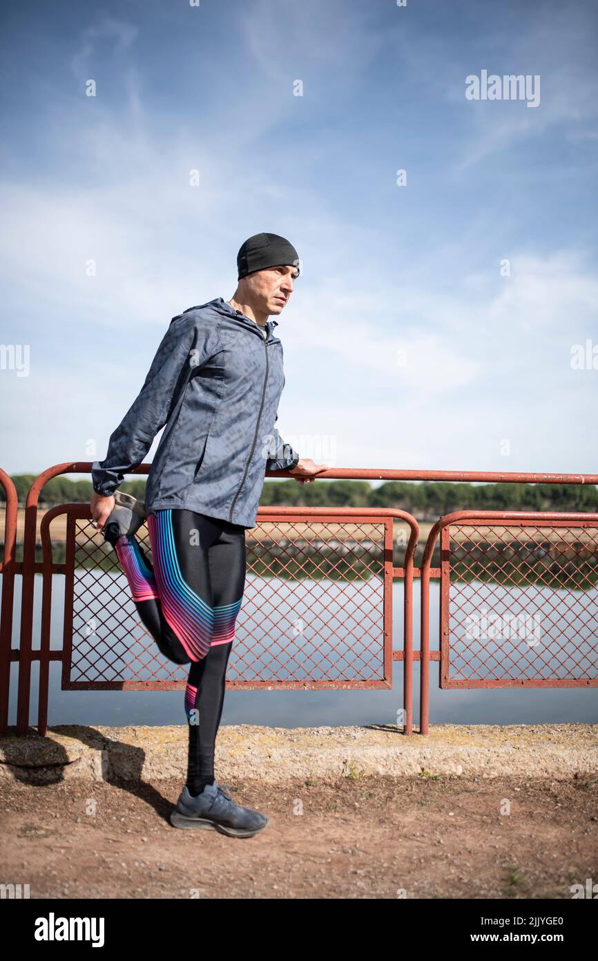 L'uomo runner allunga la gamba dopo l'allenarsi Foto Stock