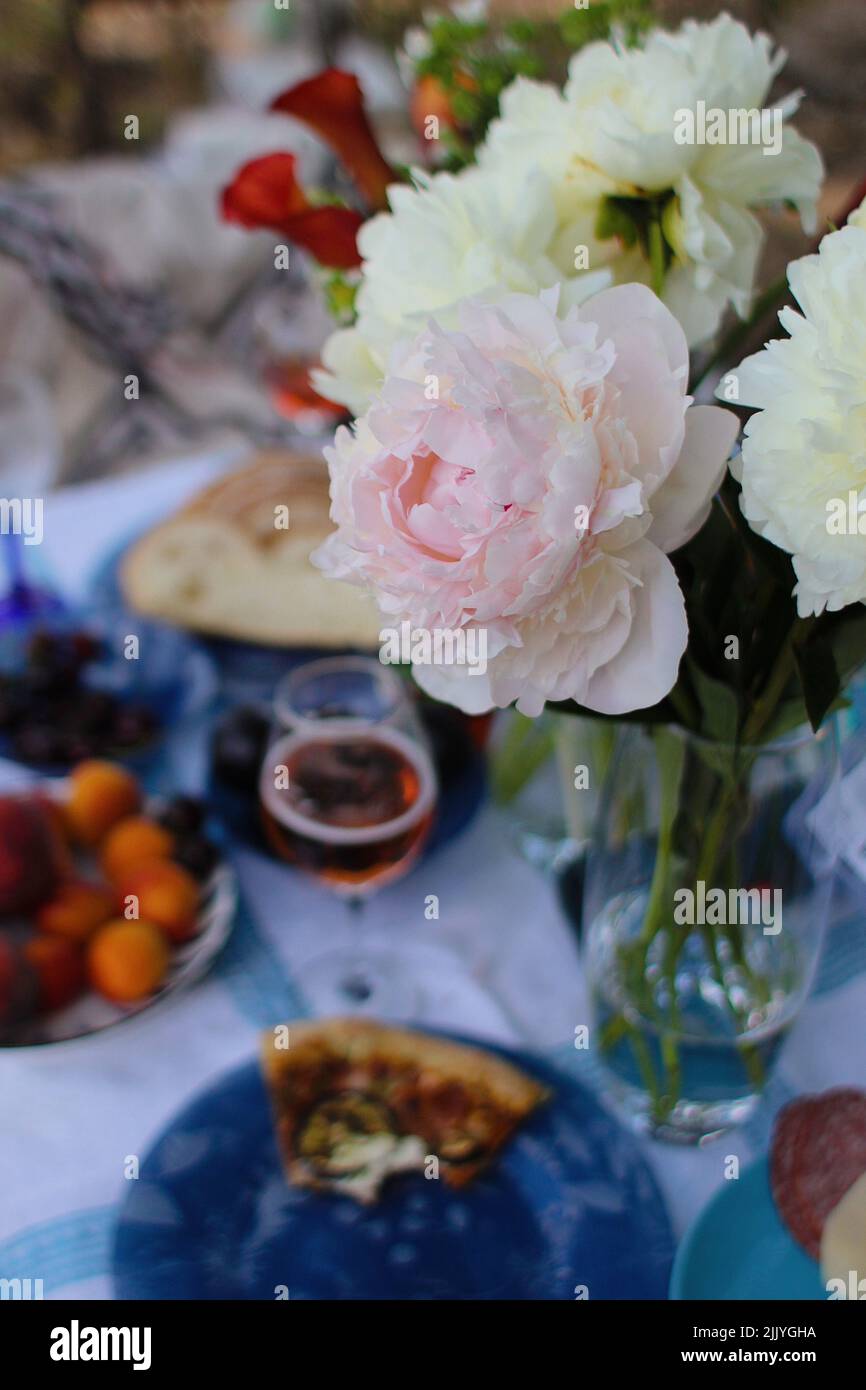 bel pic-nic con fiori pizza e vino Foto Stock