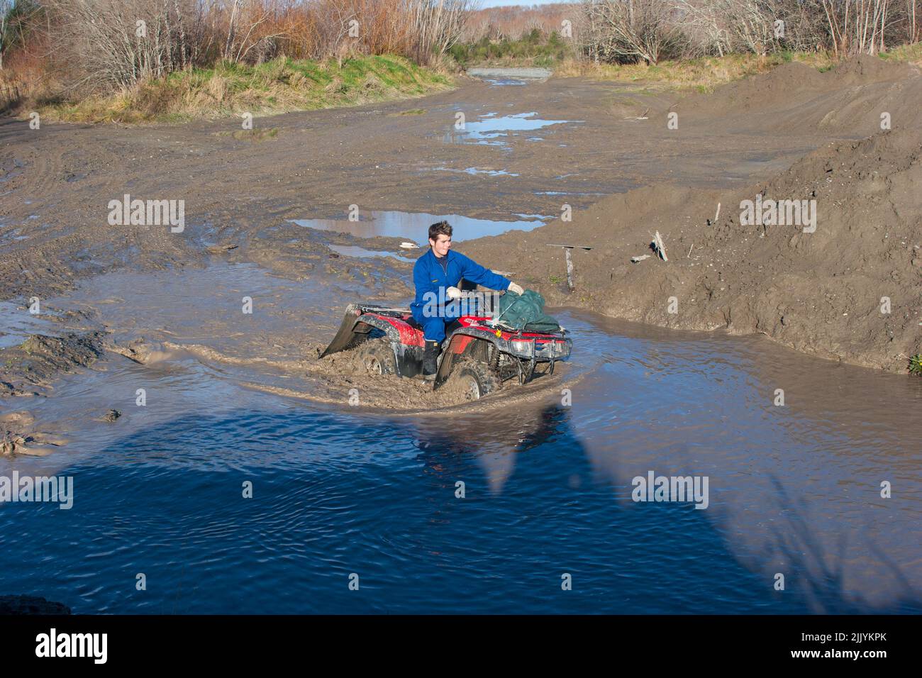 Uno sguardo alla vita in Nuova Zelanda: Quad avventure sul fiume. Abbondante acqua e fango e impegnativi attraversamenti fluviali. Foto Stock