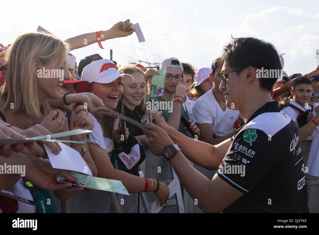 Mogyorod, Ungheria. 28th luglio 2022. Il driver cinese dell'Alfa Romeo Zhou Guanyu (fronte, R) firma l'autografo per i tifosi durante una sessione di passeggiata nella pit lane all'Hungaroring di Mogyorod, Ungheria, 28 luglio 2022. Credit: Attila Volgyi/Xinhua/Alamy Live News Foto Stock