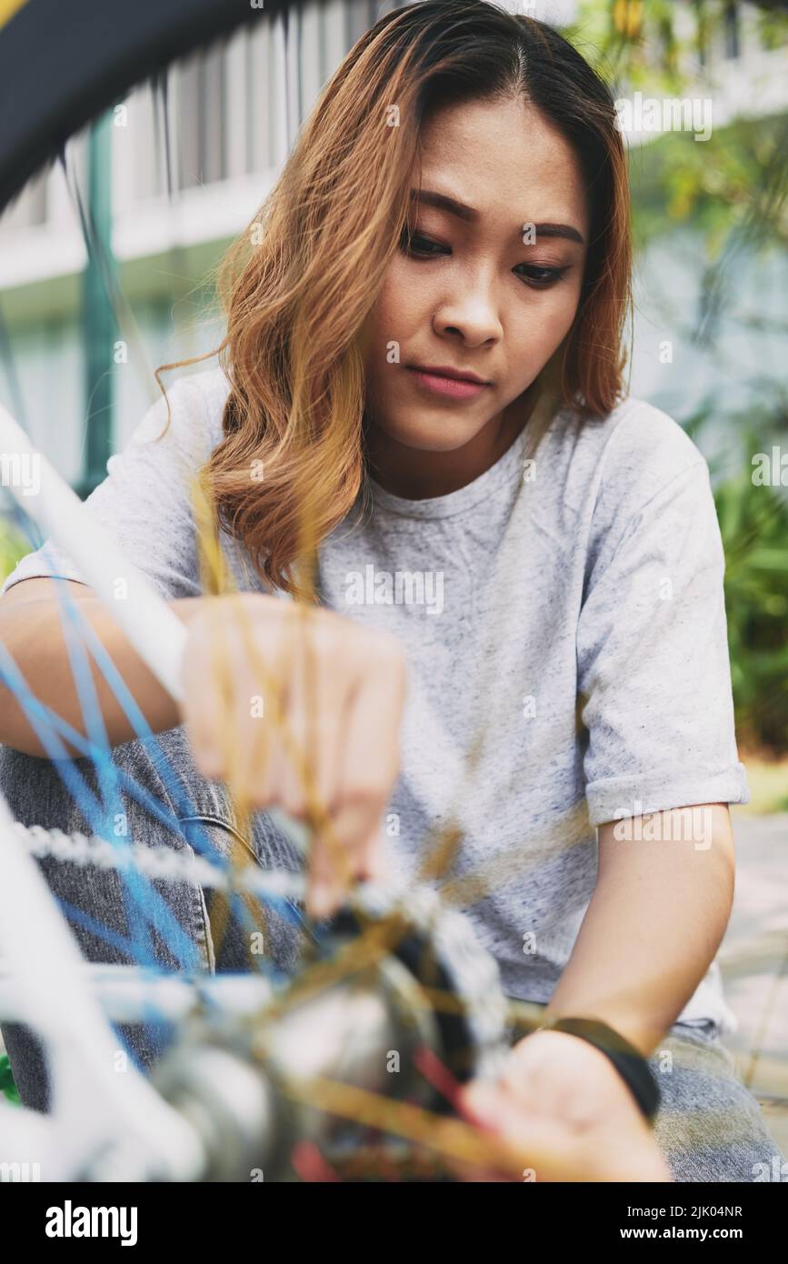 Catena di fissaggio femminile vietnamita sulla sua moto Foto Stock