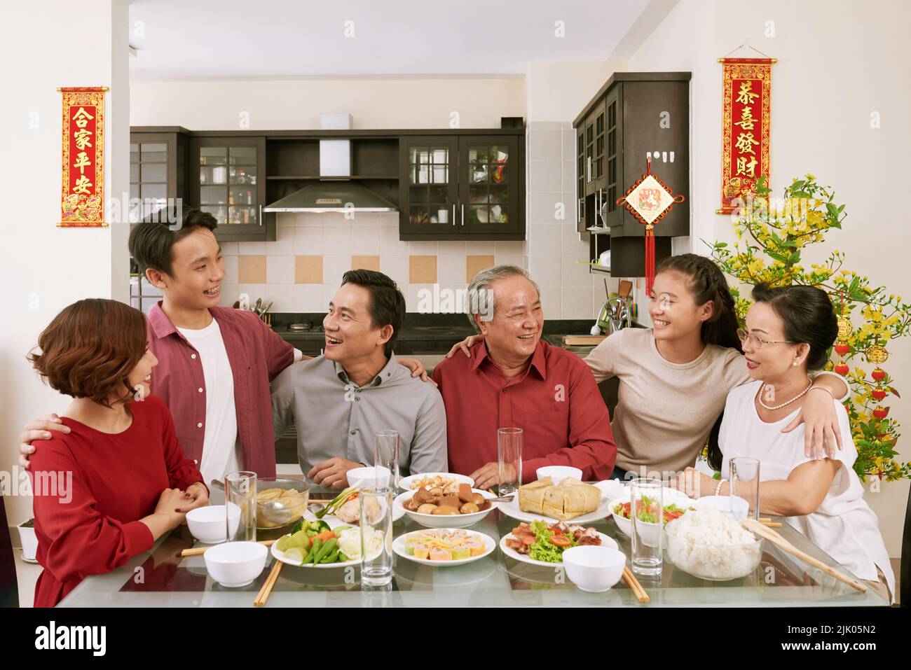 I membri allegri della famiglia parlano alla cena cinese di Capodanno. Scorre desiderio di fortuna e ricchezza in background Foto Stock