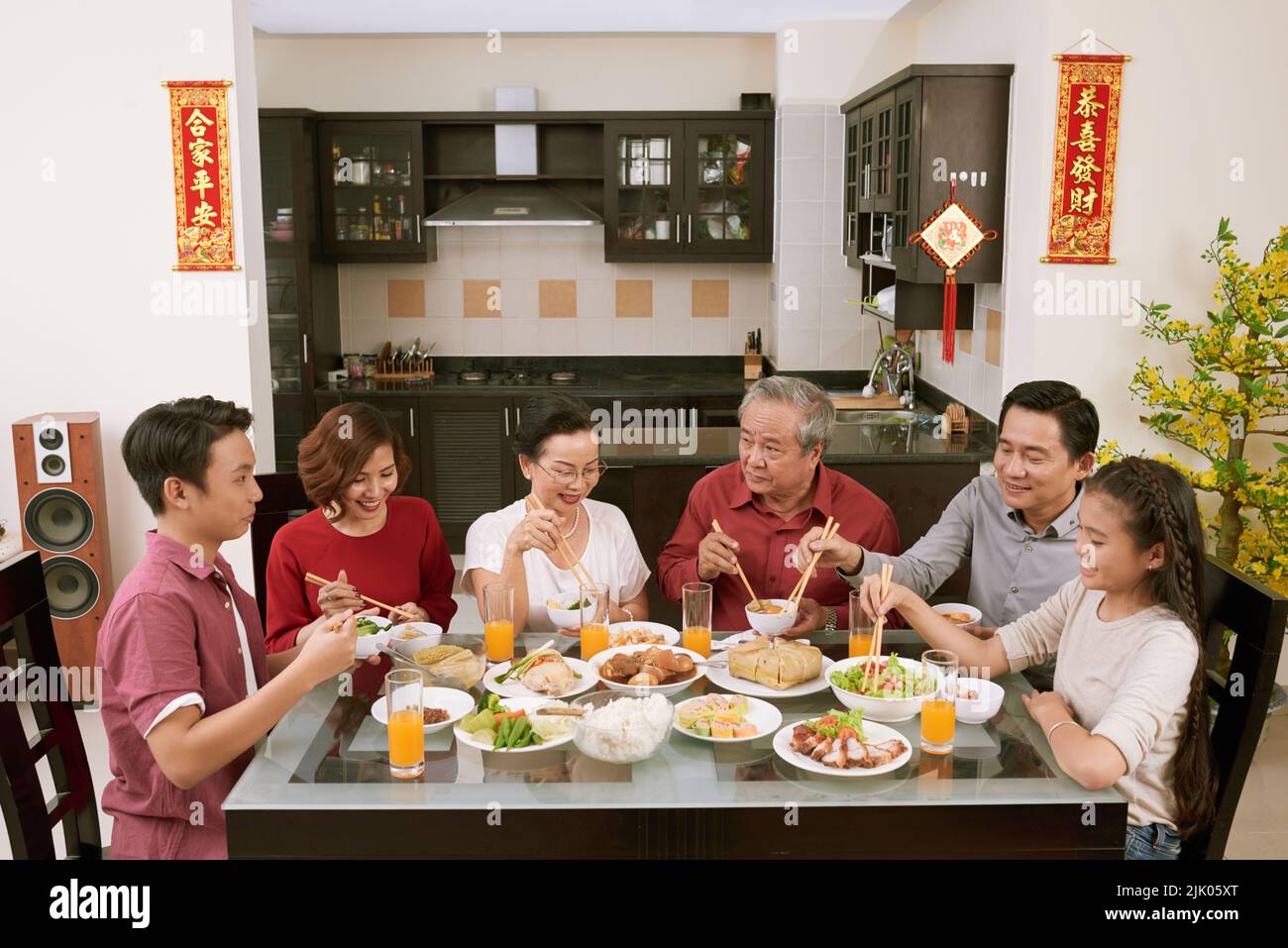 Grande famiglia asiatica godendo la festa cinese di Capodanno in casa. Scorre desiderio di fortuna e ricchezza in background Foto Stock