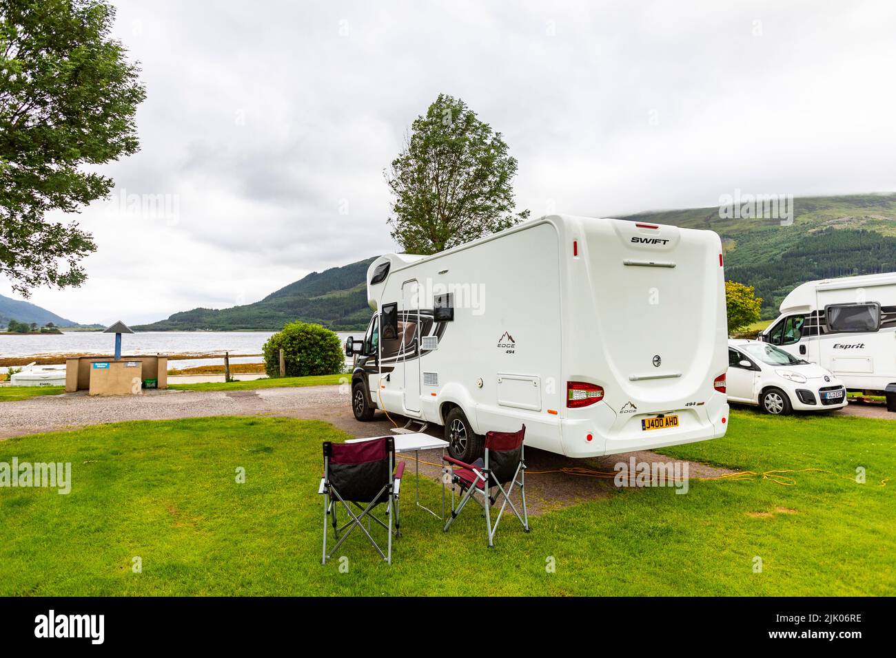 Glencoe, camper Swift EDGE con sedie esterne e tavolo parcheggiati al parco automobilistico di Invercoe che si affaccia su Loch Leven, Highlands scozzesi, Regno Unito Foto Stock