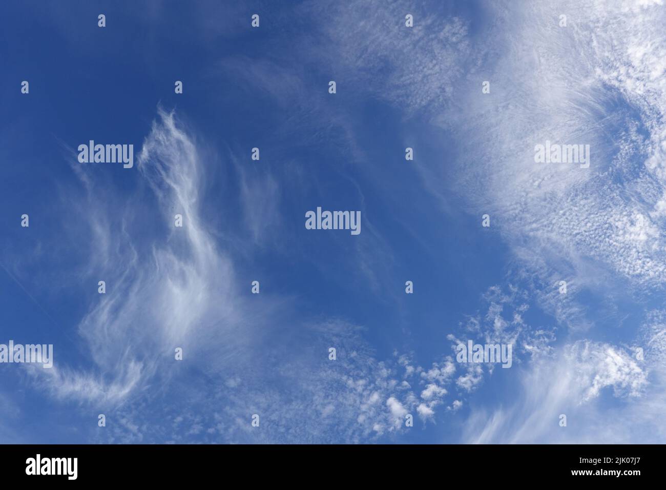 Le nuvole di Cirrus nel cielo blu, sottili e spesse, formate da cristalli di ghiaccio ad alta quota Foto Stock