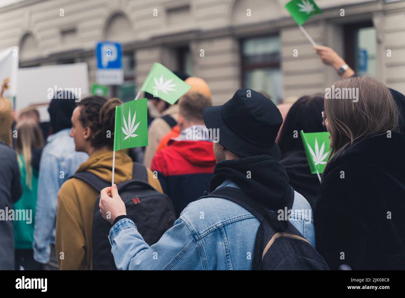 Democrazia e libertà di protestare concetto. Giovani europei che lottano per la cannabis ricreativa legale. Bandiere verdi con foglia bianca a forma di erbaccia. Foto di alta qualità Foto Stock