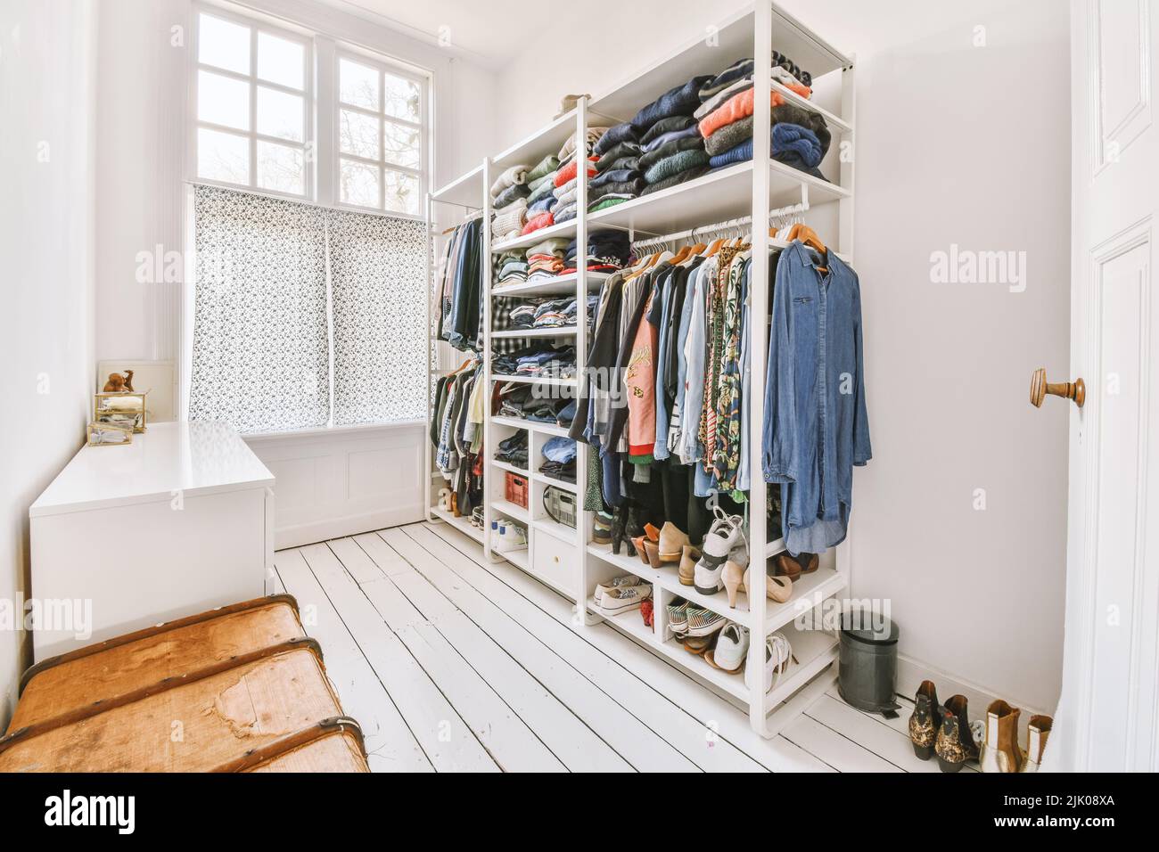 guardaroba bianco con specchi vicino alla chitarra e cabinet nella stanza luminosa di casa Foto Stock