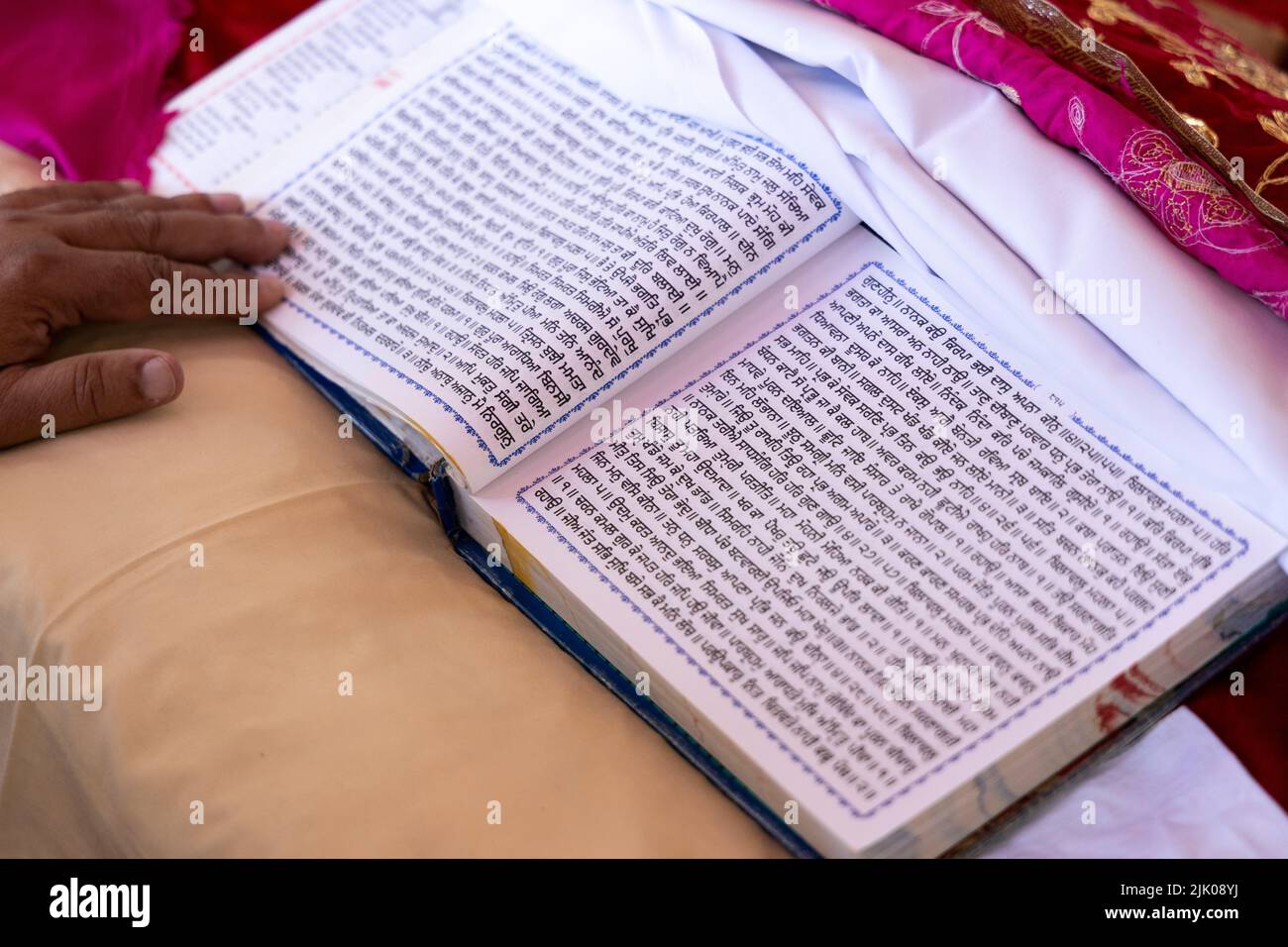 Guru Granth Sahib Sacra Scrittura religiosa di Sikhism. Linguaggio punjabi scritto su pagine bianche religiose nella cerimonia nuziale. Foto Stock