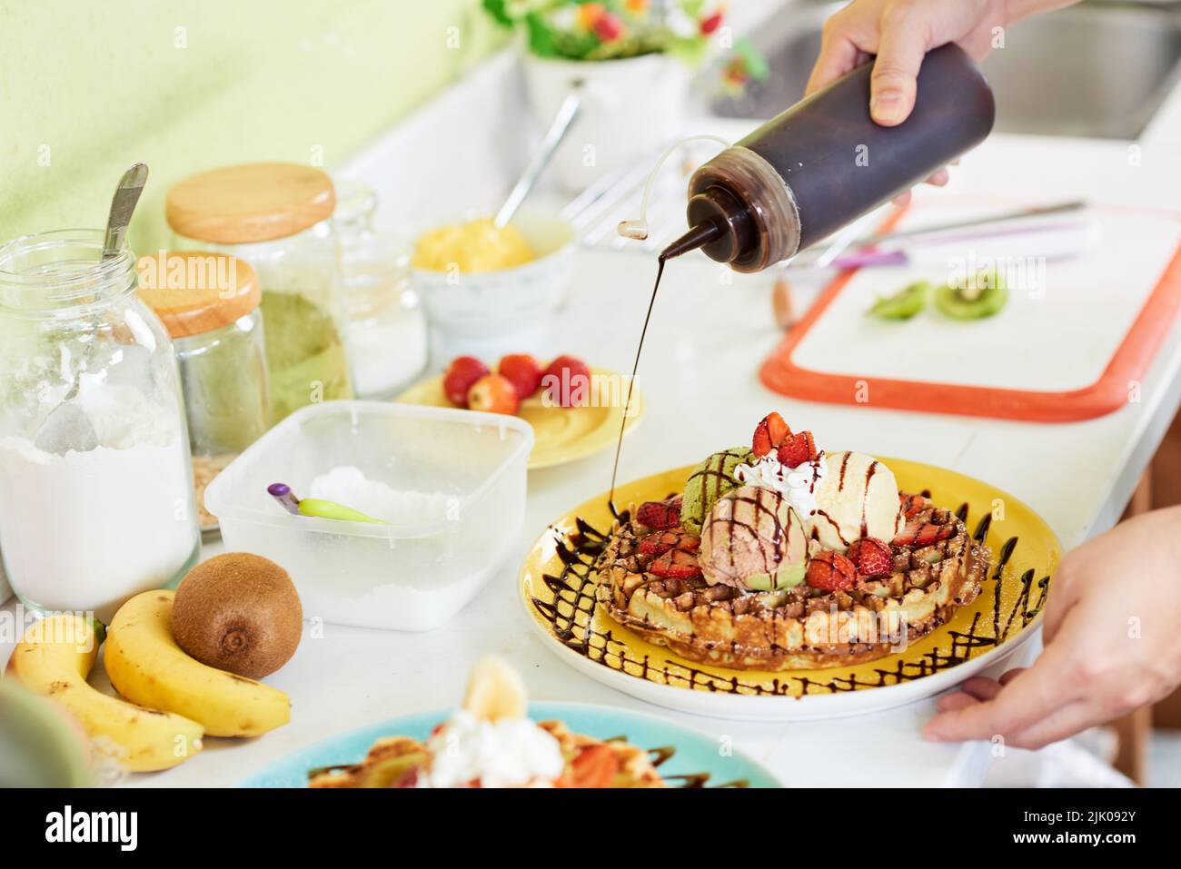 Dolciumi con sciroppo di cioccolato per decorare la piastra con cialda Foto Stock
