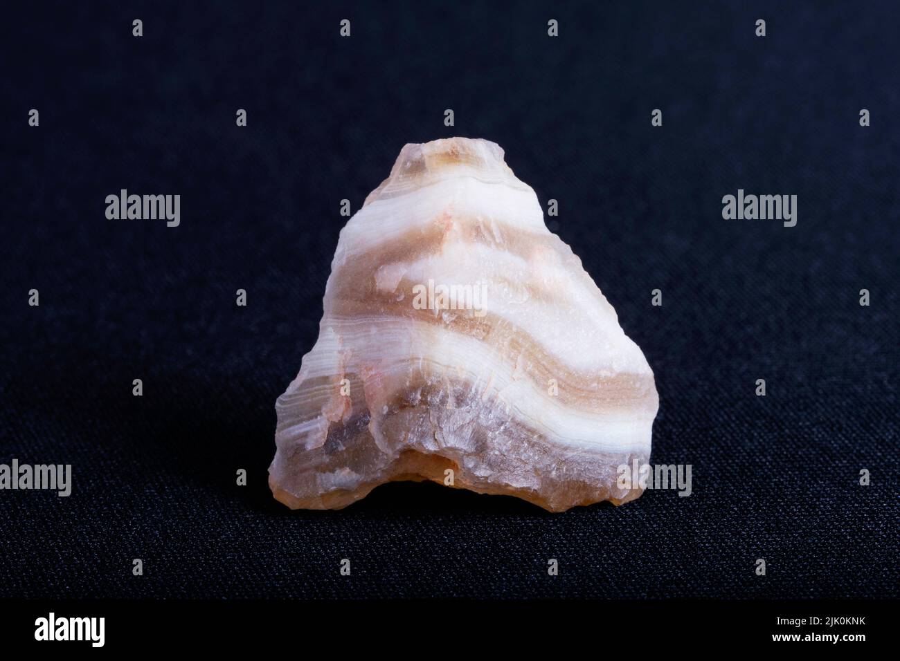 Agata a bande scure. Agate è una formazione rocciosa comune, costituita da calcedonia e quarzo come suoi componenti primari, con un'ampia varietà di colori. Foto Stock