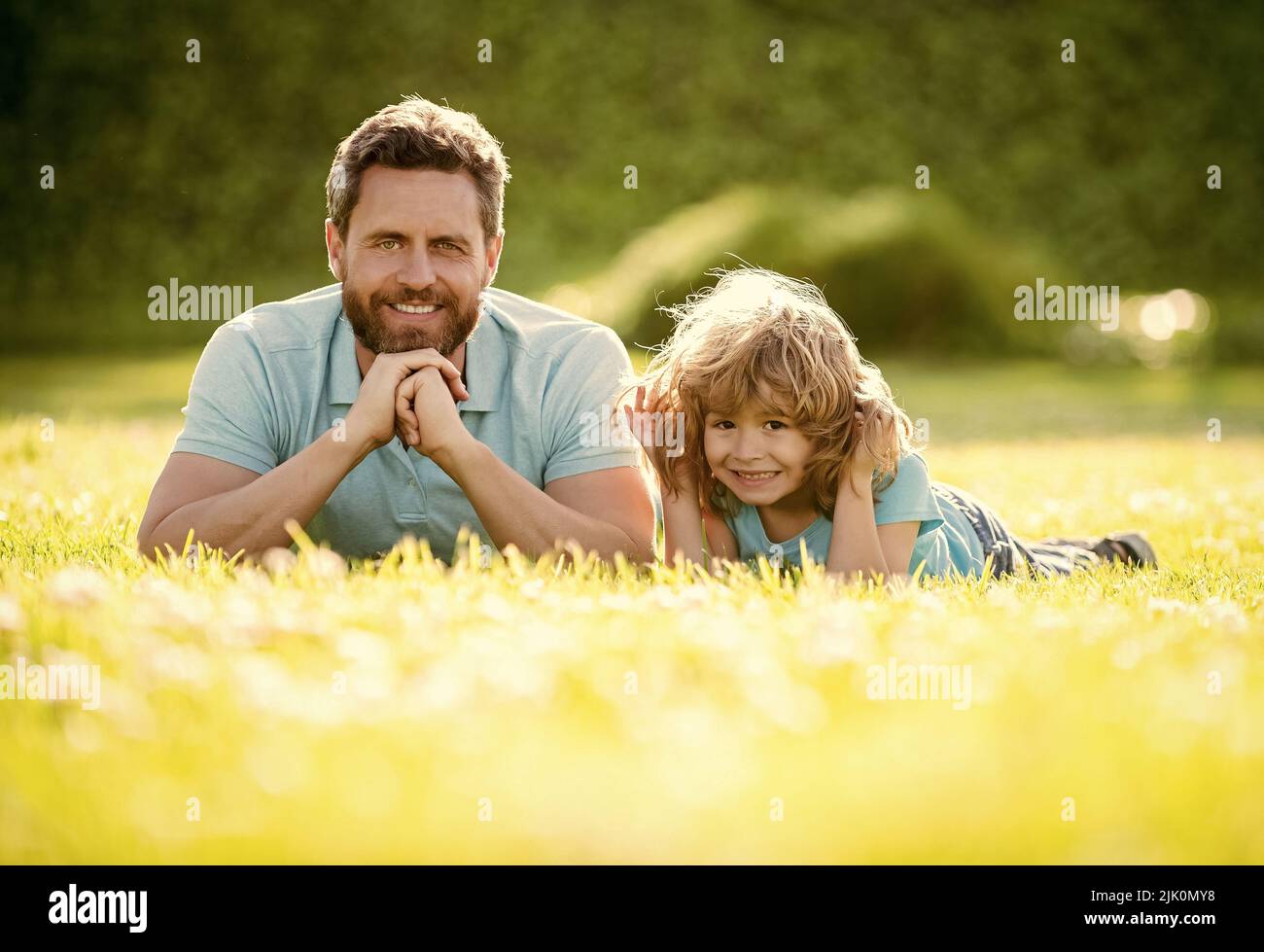 famiglia felice di padre e figlio bambino rilassarsi nel parco estivo erba verde, paternità Foto Stock