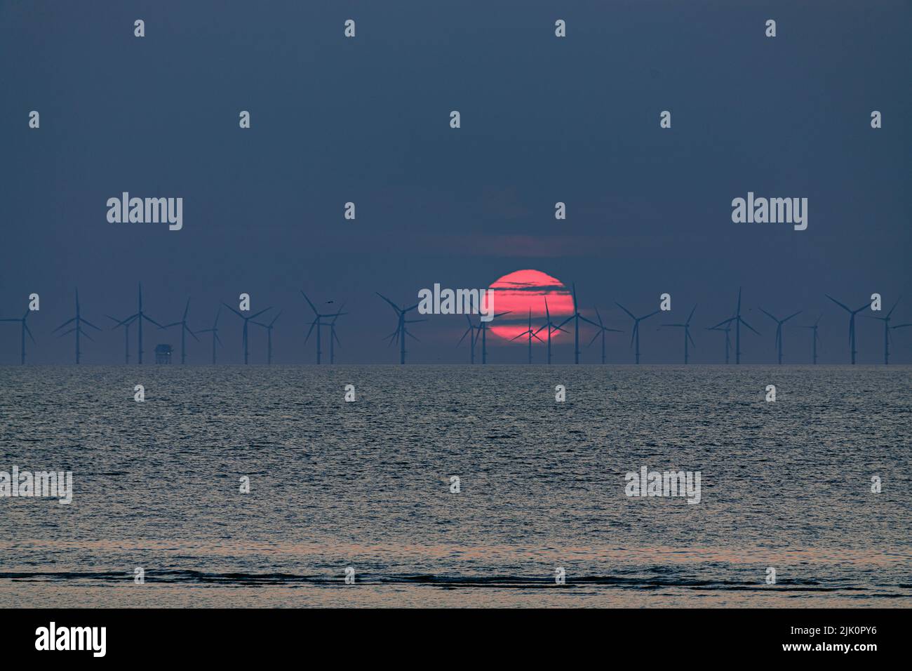 Tramonto sulle turbine eoliche offshore, Prestatyn sulla costa settentrionale del Galles Foto Stock