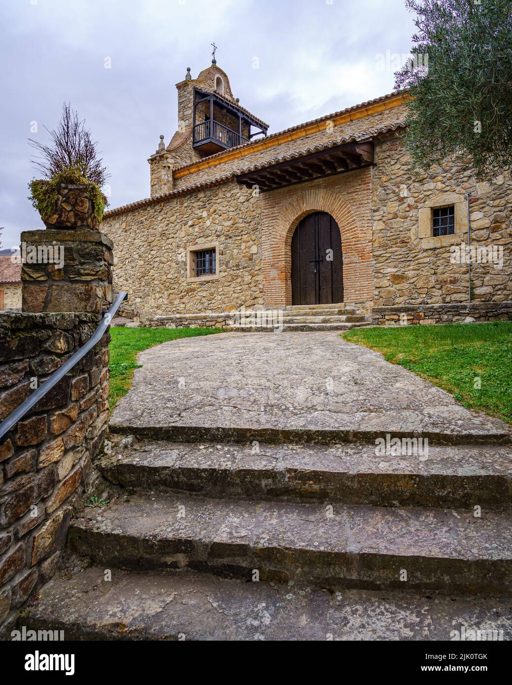 Antica chiesa medievale in pietra con accesso scala e torre con balcone. Horcajuelo Madrid. Spagna. Foto Stock
