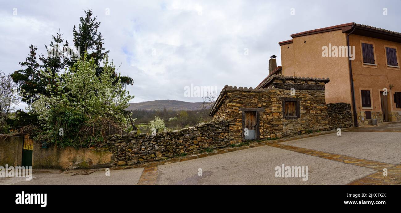 Panoramica di vecchie case in un vicolo di un borgo medievale in una giornata nuvolosa. Spagna. Foto Stock