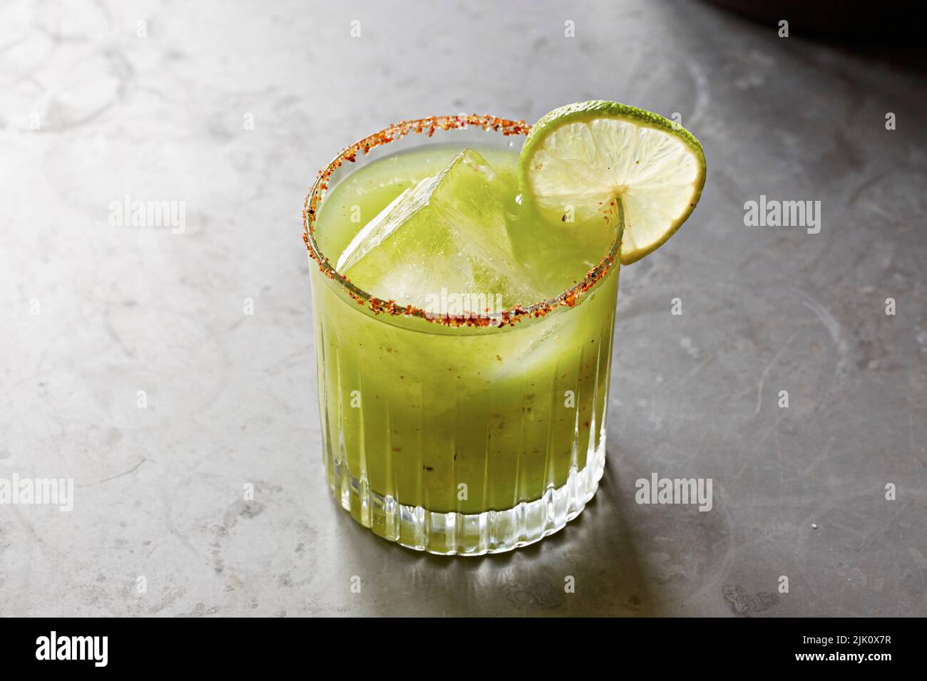 Cocktail verde guarnito con lime e un bordo di sale peperoncino Foto Stock