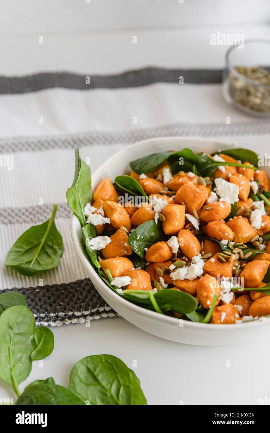 Gnocchi di zucca con insalata di feta e foglie di spinaci Foto Stock