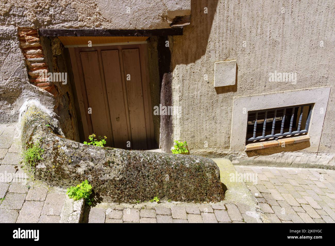 Casa della città vecchia con piccola porta di accesso e finestra accanto al terreno. Spagna. Foto Stock