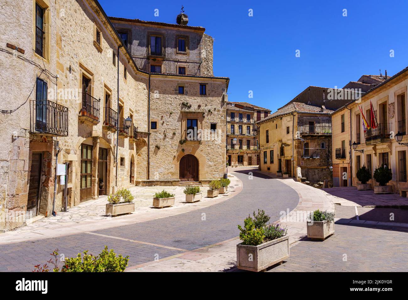 Strada della città vecchia con le sue case in pietra e le scatole di fiori con piante. Sepulveda. Castilla Foto Stock