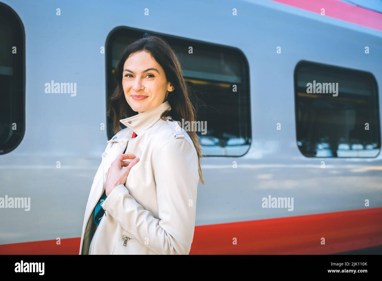 Ritratto di una donna in viaggio d'affari che cammina in una stazione ferroviaria o aeroporto andando al cancello d'imbarco con bagaglio a mano Foto Stock