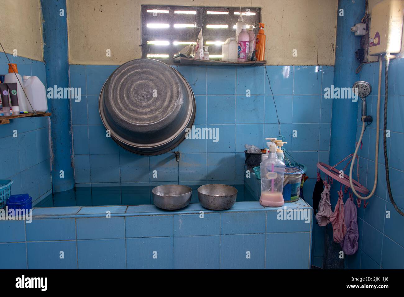 Un bagno con un grande serbatoio d'acqua in una casa tailandese Foto Stock