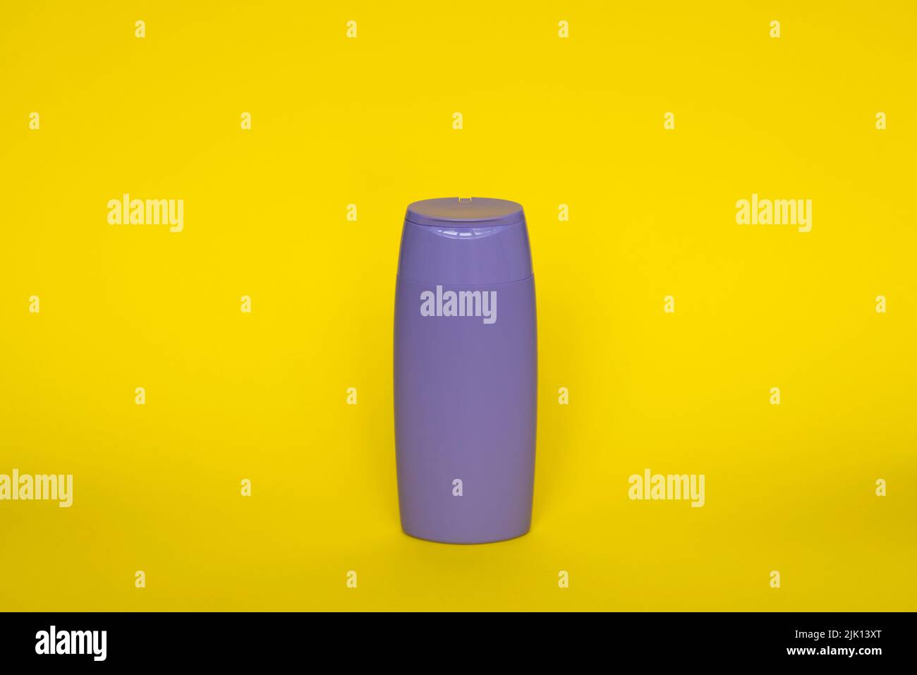 Bottiglia di plastica viola di prodotti per la cura del corpo e di bellezza. Studio fotografico di bottiglia di plastica per shampoo, gel doccia, crema isolato su giallo Foto Stock