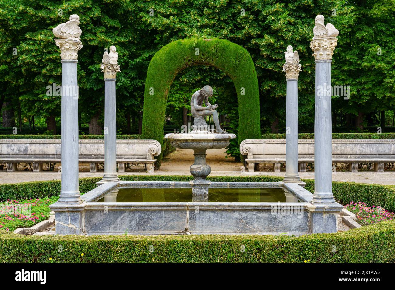 Bell'angolo di parco pubblico con vecchie colonne di pietra bianca e posti a sedere per rilassarsi. Aranjuez. Foto Stock