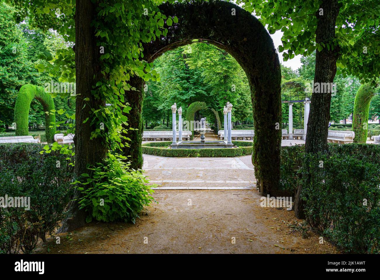 Bell'angolo di parco pubblico con vecchie colonne di pietra bianca e posti a sedere per rilassarsi. Aranjuez. Foto Stock