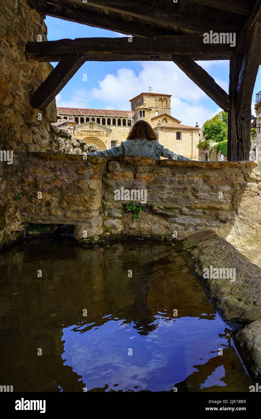 Donna sulla schiena che riposa e contempla vista nel vecchio villaggio di pietra. Santilla del Mar, Santander. Foto Stock