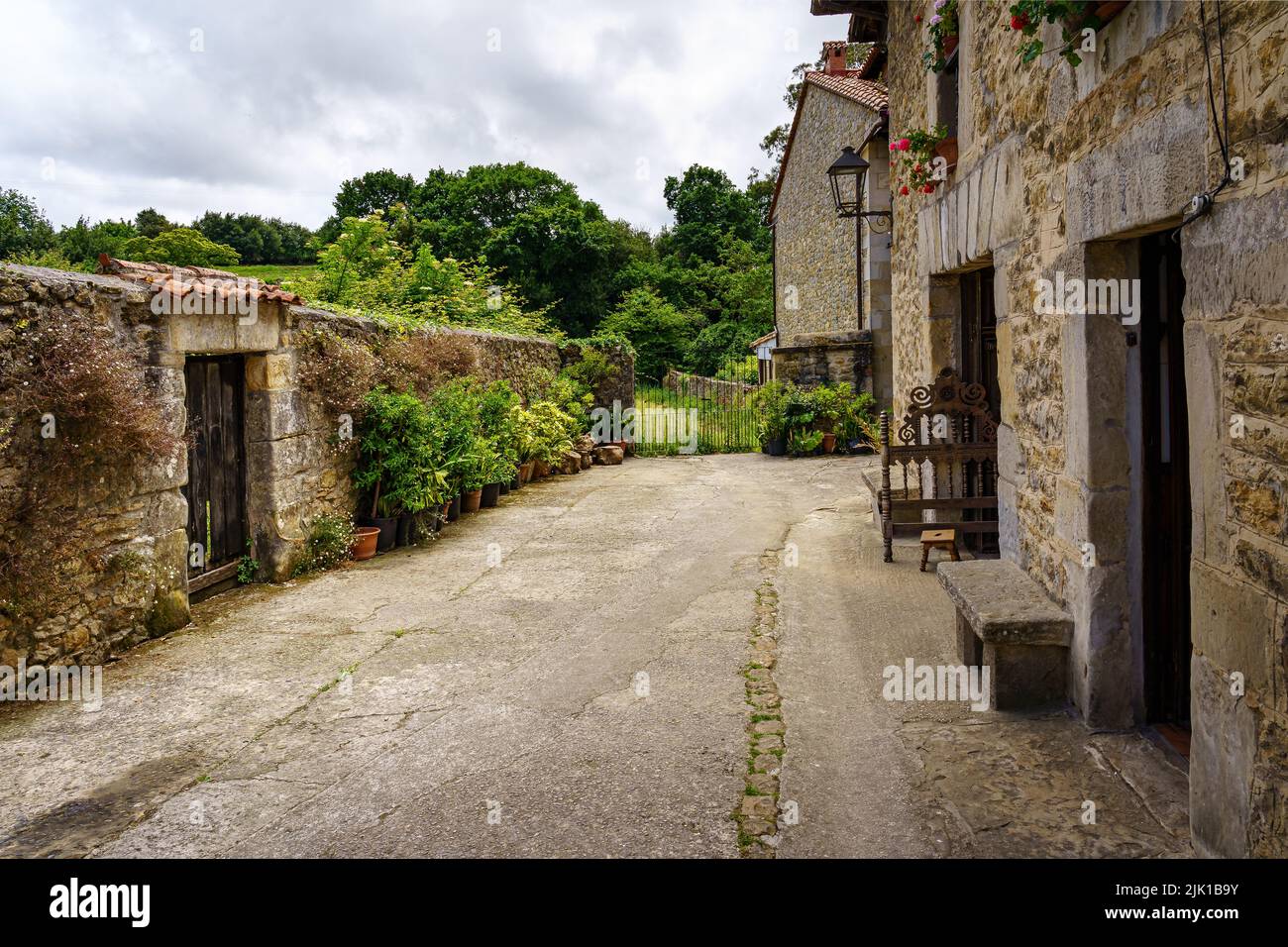 Angolo di una città vecchia con case in pietra e muri con fiori. Santillana del Mar. Foto Stock