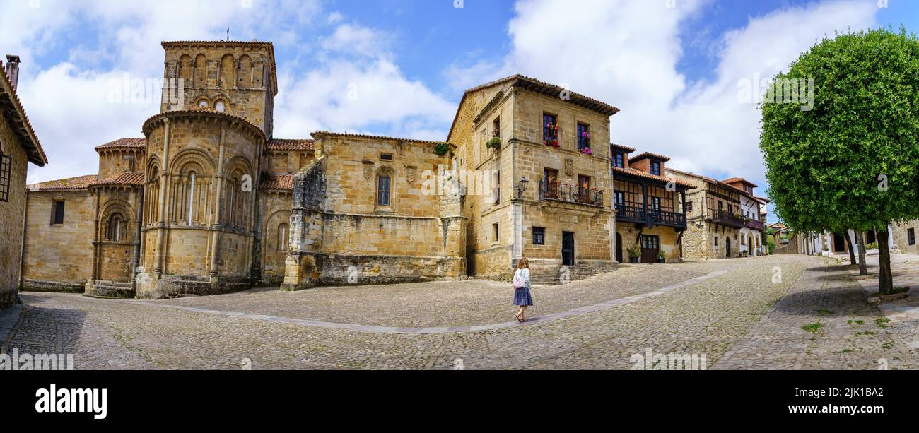 Panoramica delle case medievali della città vecchia con una donna che cammina per le sue strade. Santillana del Mar, Cantabria. Foto Stock