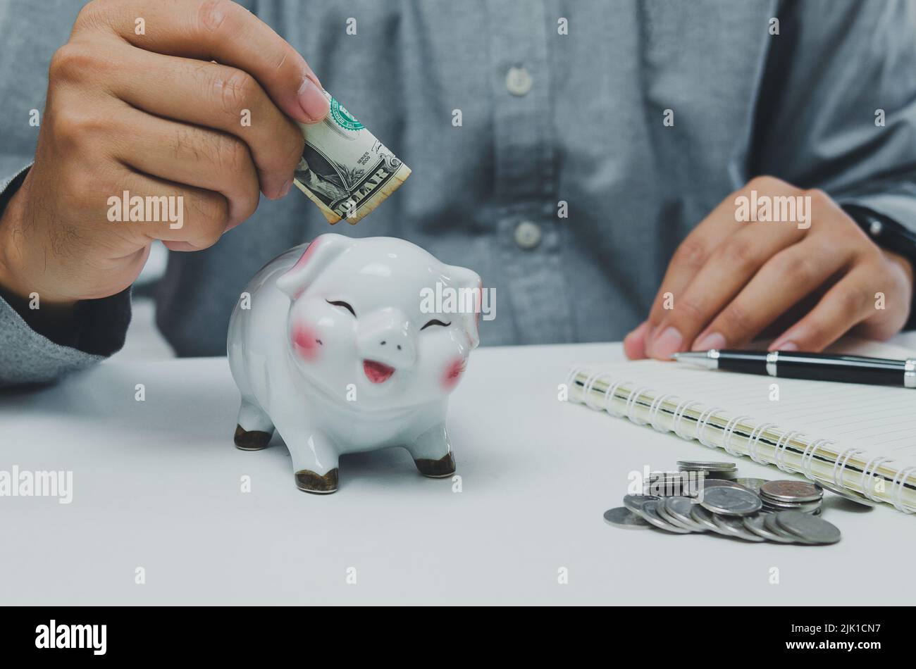 Uomo persona che detiene dollaro risparmio bancario piggybank.Business finanza economia di investimento e concetto di previdenza fiscale sicuro. Foto Stock