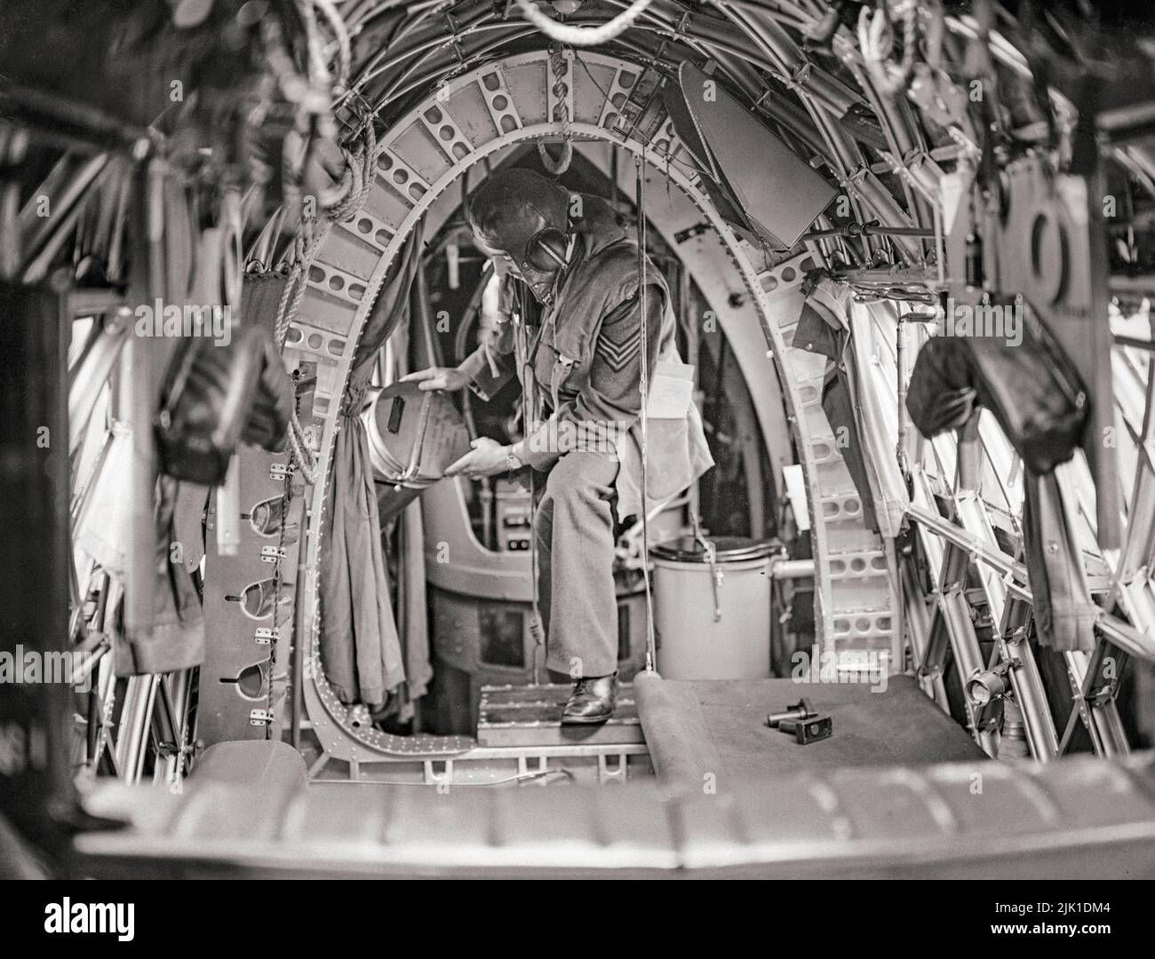 Un membro dell'equipaggio a bordo di un Vickers Wellington di No. 75 (Nuova Zelanda) Squadron RAF mette i razzi notturni in posizione nella fusoliera posteriore stretta. Il Wellington era un bombardiere medio a lungo raggio a doppia potenza, progettato a metà del 1930s come bombardiere notturno nei primi anni della seconda guerra mondiale, che si esibiva come uno dei principali bombardieri fino a quando non fu sostituito dalle più grandi 'avies' a quattro engineed come l'Avro Lancaster. Si distingue per essere stato l'unico bombardiere britannico prodotto per tutta la durata della guerra. Foto Stock