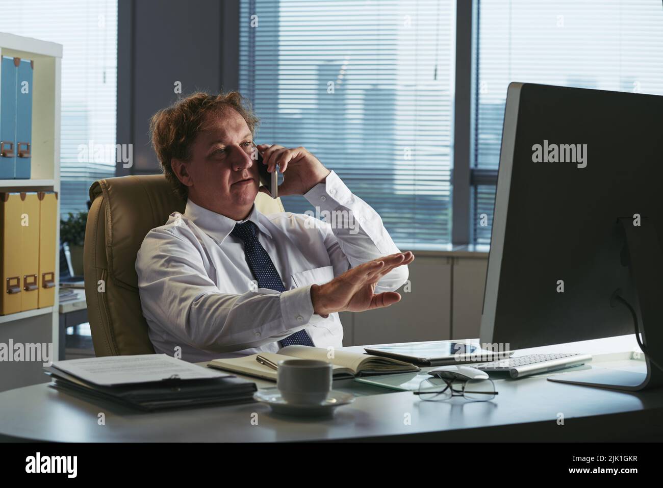 Uomo d'affari che chiama un collega al telefono Foto Stock