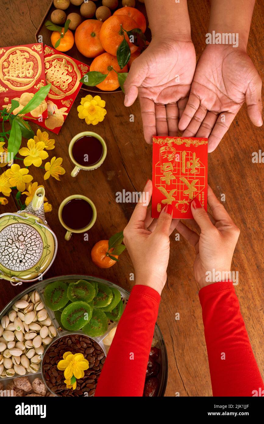 Mani di donna che danno busta di soldi fortunati con i migliori auguri inscriptionto suo amico Foto Stock