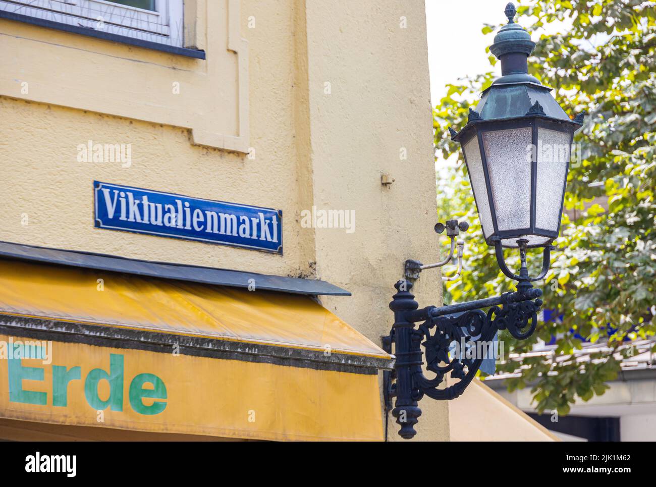 Monaco di Baviera, Germania - 6 luglio 2022: Segnaletica stradale del Viktualienmarkt con accanto una storica lampada stradale. Viktualienmarkt è un popolare mercato alimentare quotidiano Foto Stock