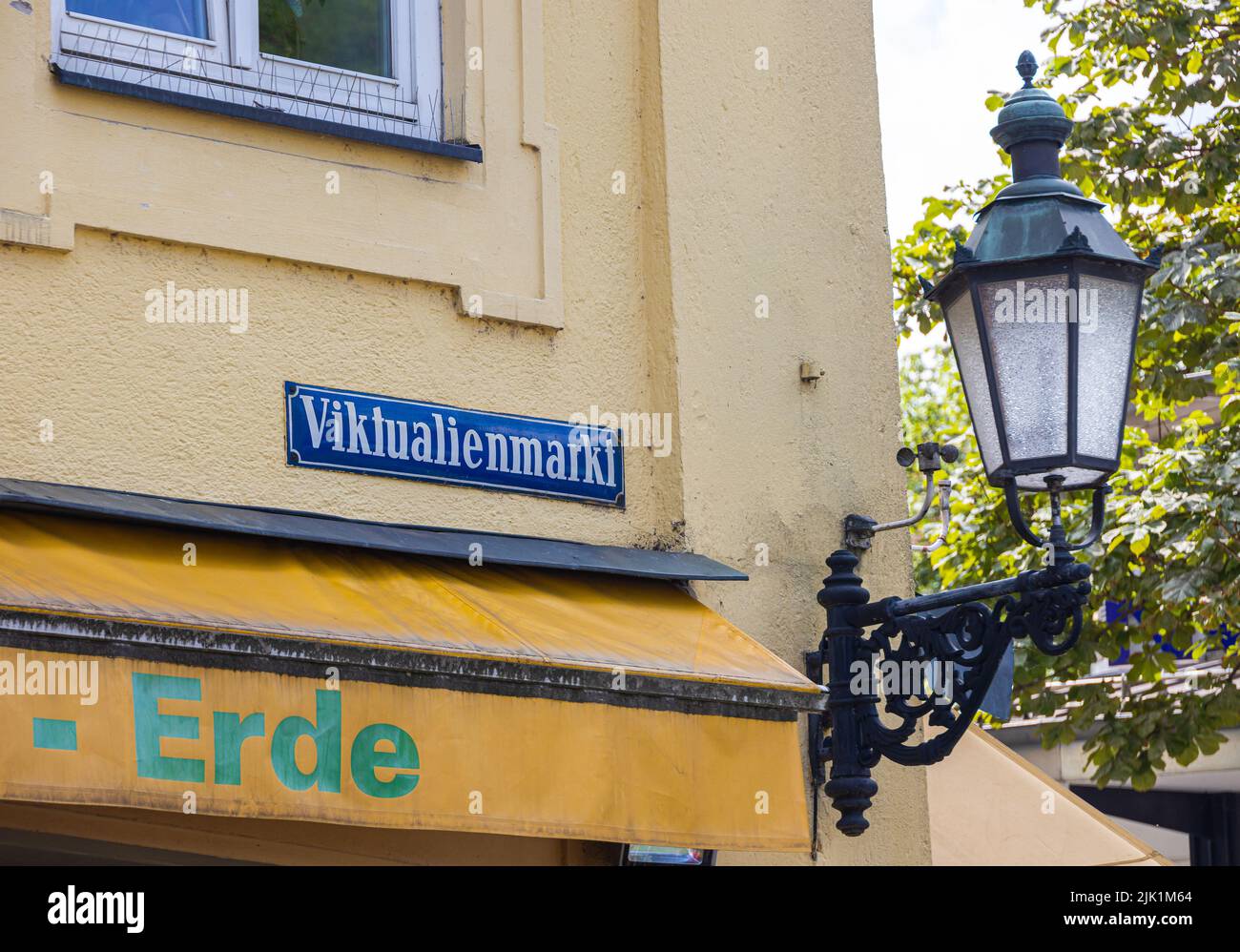 Monaco di Baviera, Germania - 6 luglio 2022: Segnaletica stradale del Viktualienmarkt con accanto una storica lampada stradale. Viktualienmarkt è un popolare mercato alimentare quotidiano Foto Stock