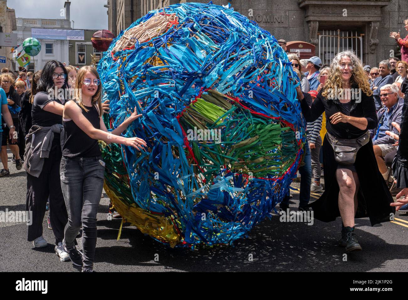 Un grande modello della Terra fatto di strisce di stoffa colorata che vengono rotolate lungo nelle celebrazioni della sfilata del Mazey Day come parte del Golowan Foto Stock