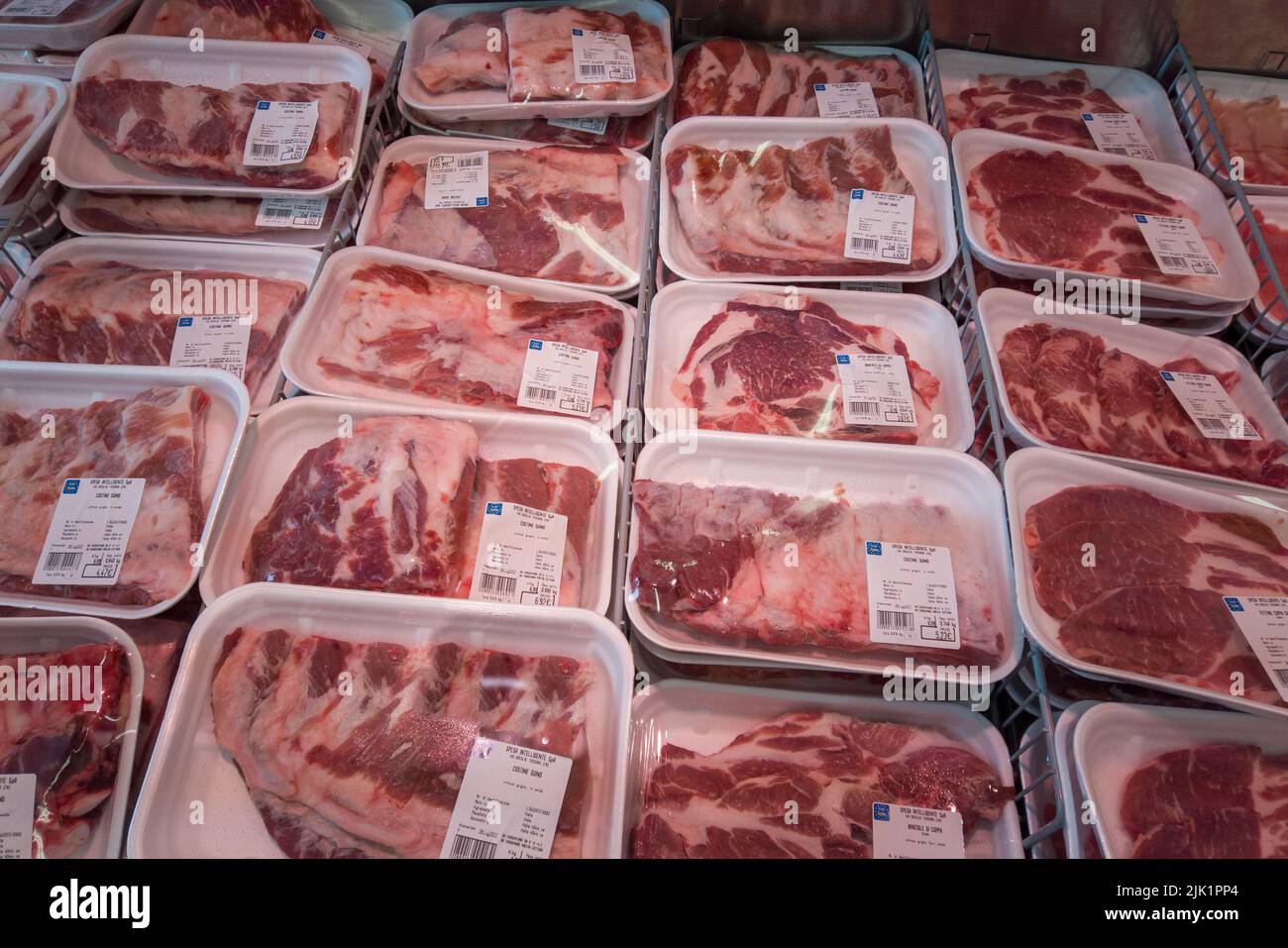 Fossano, Italia - 29 luglio 2022: Costolette di maiale crudo pronte per il barbecue in vassoi di plastica nel banco frigorifero del supermercato italiano Eurospin. Foto Stock