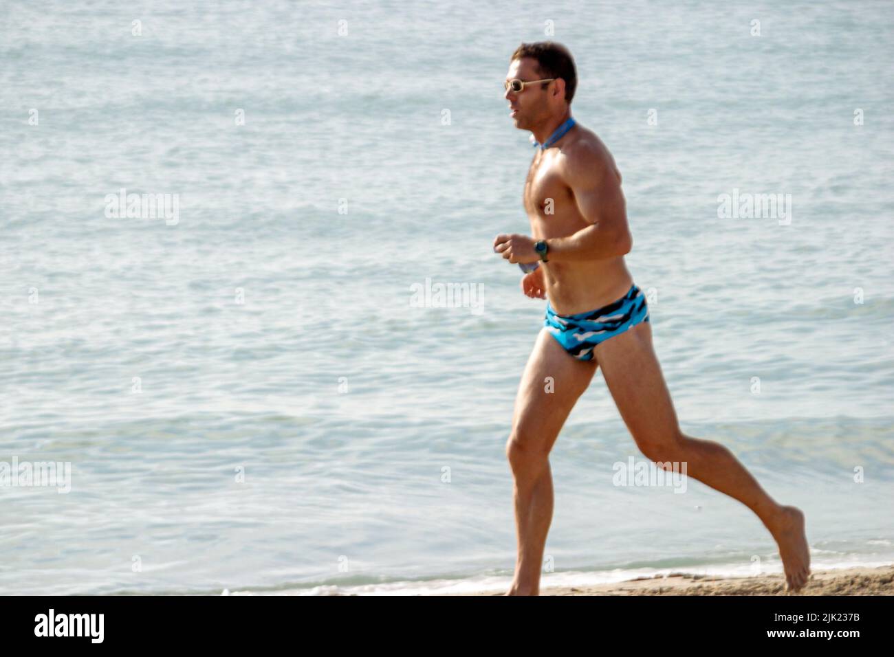 Miami Beach Florida, Atlantic Ocean Shore, litorale, adulti uomo uomo uomo maschio, jogging surf, indossare costume da bagno, turisti Foto Stock