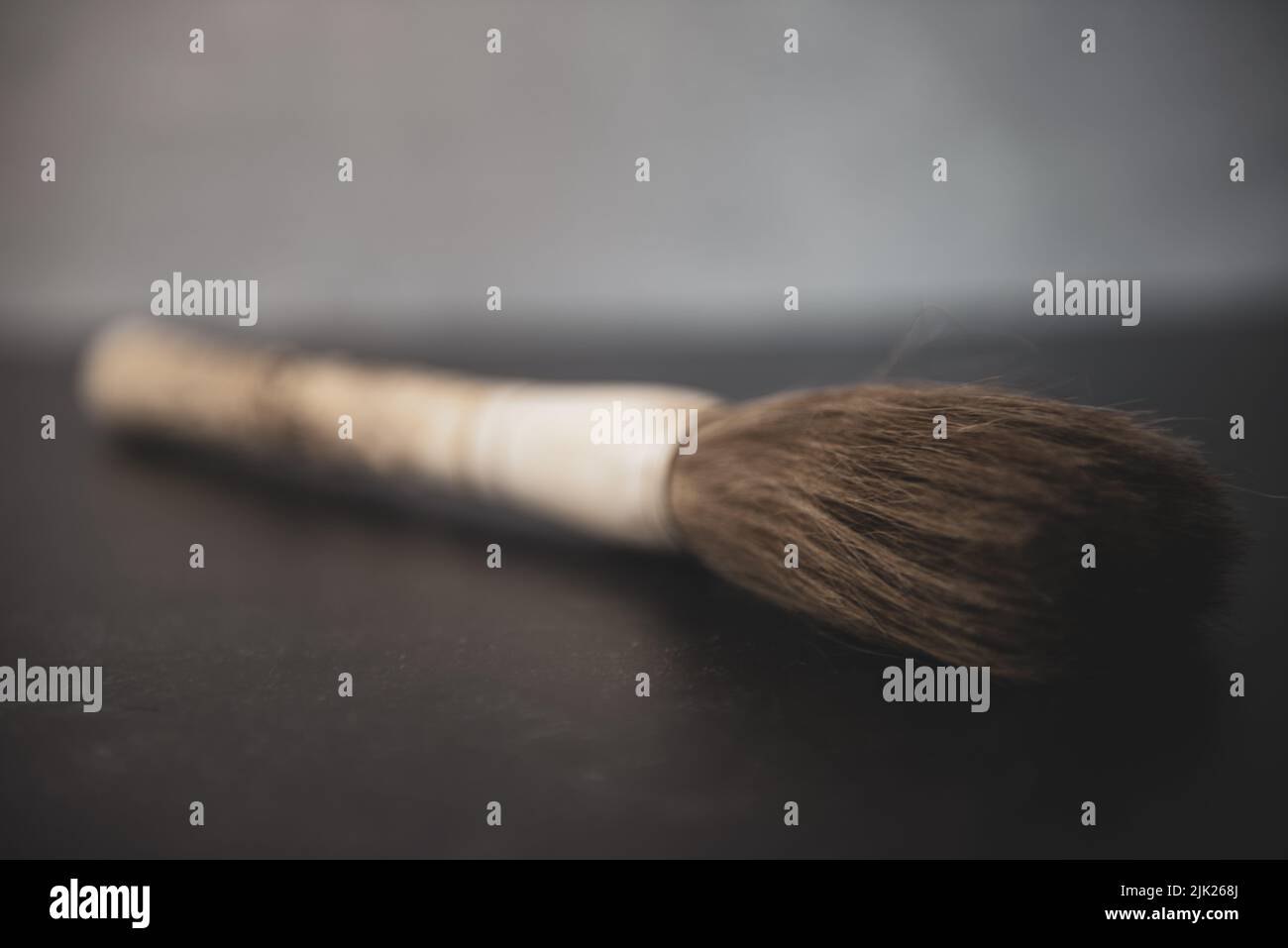Cinese mano scolpito osso pennello su sfondo grigio e nero. Messa a fuoco soft. Foto Stock