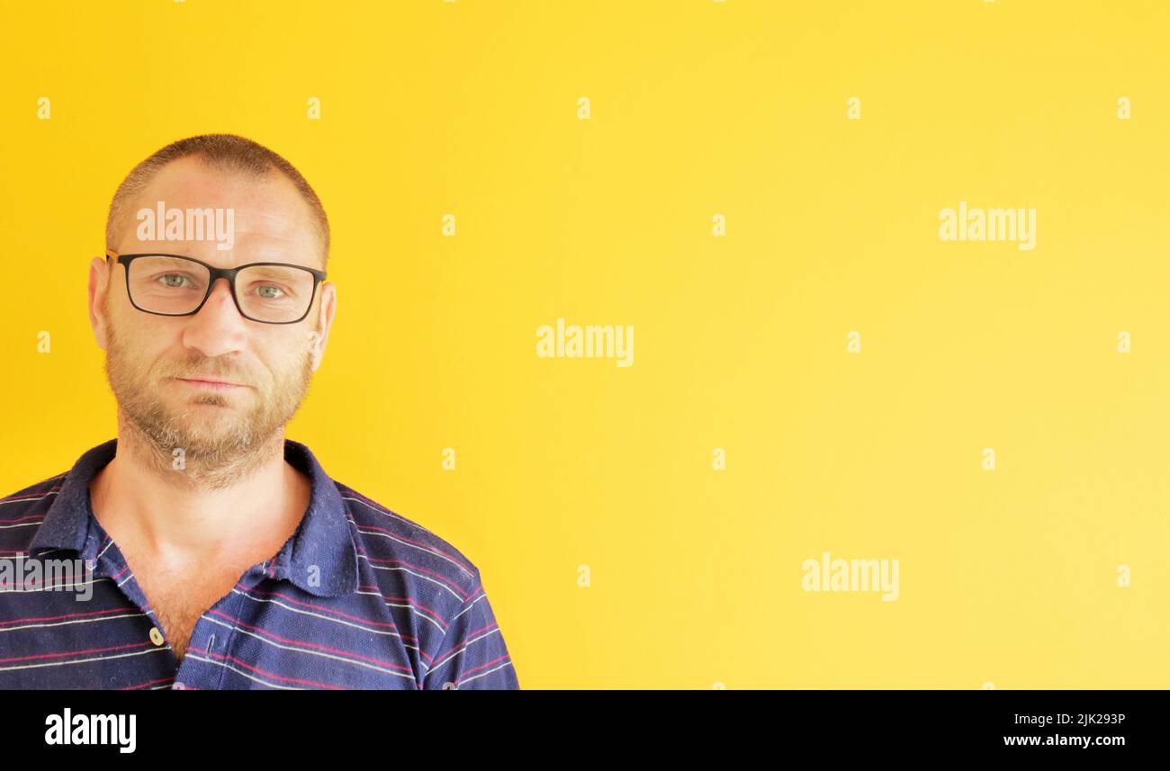 ritratto di un uomo con occhiali su sfondo giallo. spazio copia Foto Stock