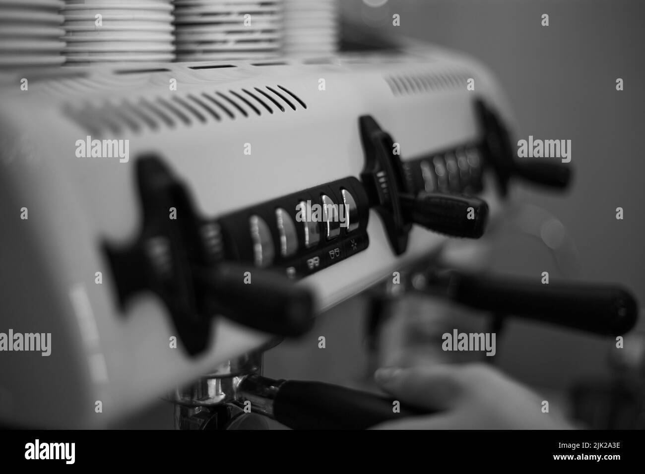 Il barista tiene in mano un portadocumenti e prepara il caffè con una macchina da caffè a doppia caldaia Foto Stock