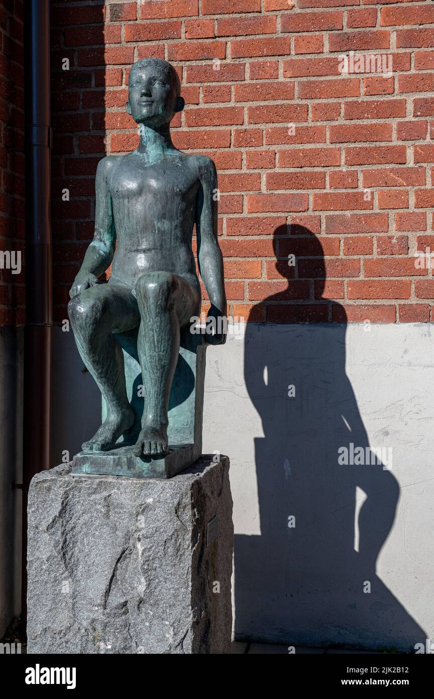 “Sitting Boy” una scultura in bronzo di Bror Marklund del 1936 nel parco delle sculture del museo d’arte di Norrkoping a Norrkoping, Svezia. Foto Stock