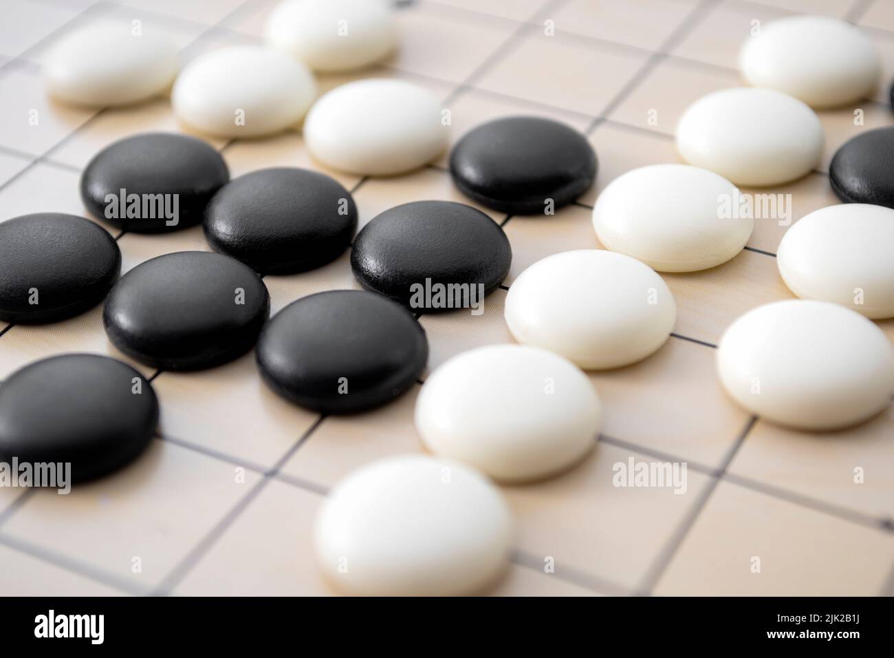 Primo piano completo del tabellone con il concetto di pezzi in pietra bianca e nera per strategia intelligente, giochi di difficoltà e intelligenza competitiva (continua Foto Stock