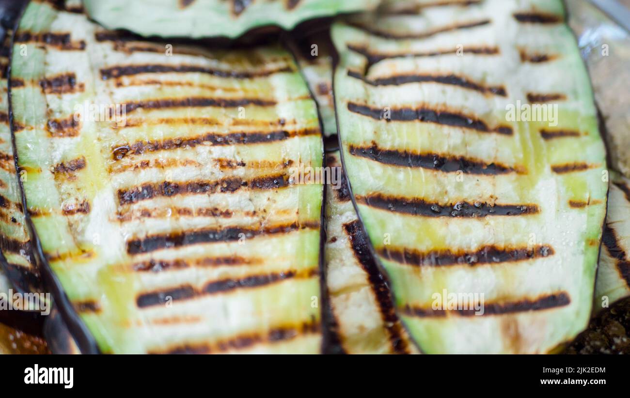 grigliare zucchine organiche su una padella. Primo piano verdure grigliate affettate veggie processo di snacking. Cibo in quarantena Foto Stock