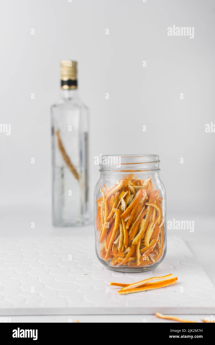 Preparazione dell'estratto d'arancia, buccia d'arancia in un vasetto di vetro, scorza d'arancia tagliata a fette Foto Stock
