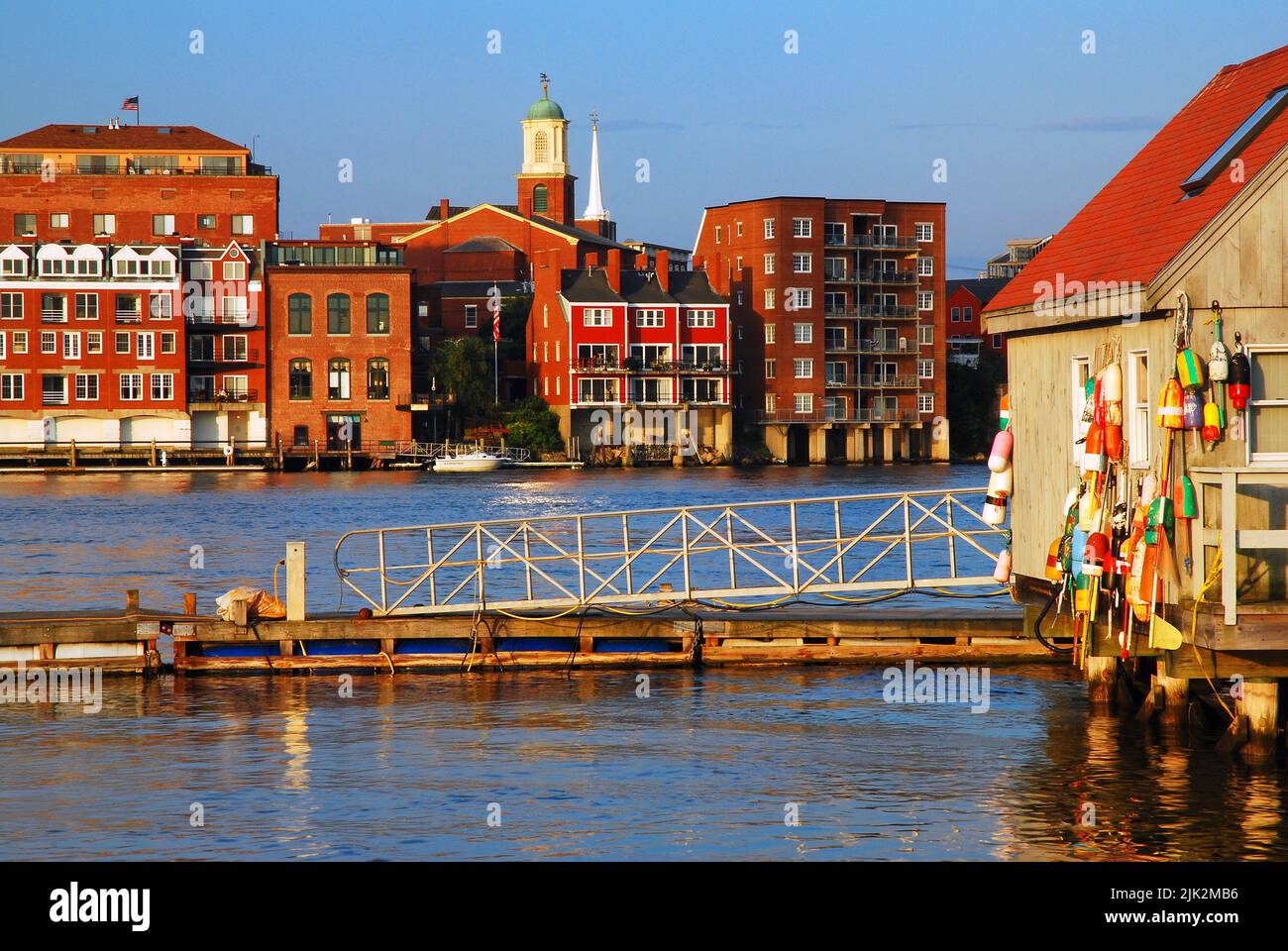Un rustico baracca al mare con colorate boe di aragosta contrasta con il nuovo sviluppo del lungomare di Portsmouth, New Hampshire Foto Stock